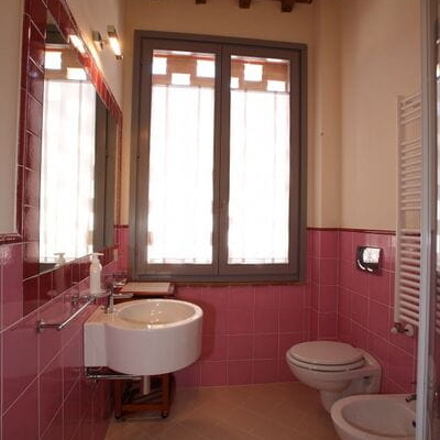 bagno con ampia finestra e rivestimento rosa